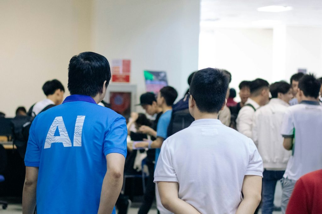 man in white and blue crew neck t-shirt standing in front of people